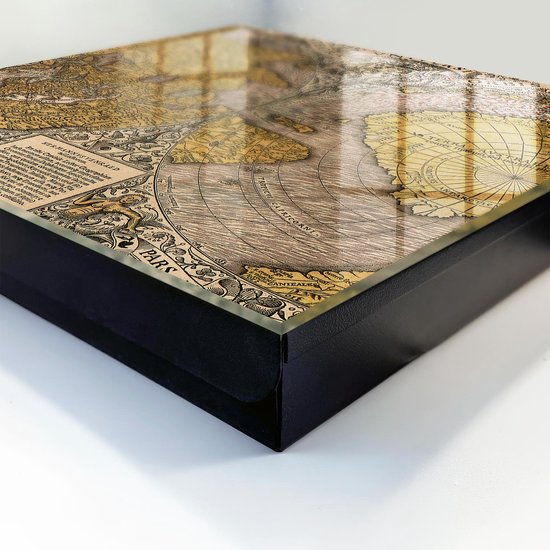 Detail van de hoek van een zwarte opbergdoos met een glazen deksel met antieke wereldkaart.