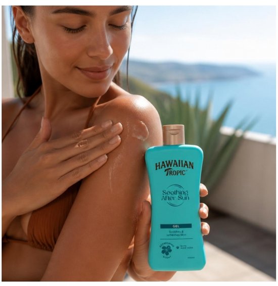 Vrouw met bruine huid smeert Hawaiian Tropic Soothing After Sun lotion op haar schouder.