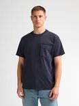 Close-up van model in donkerblauw T-shirt met borstzak.