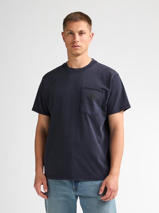 Close-up van model in donkerblauw T-shirt met borstzak.