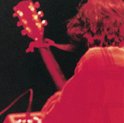 Jeff Buckley met gitaar, rood verlicht, zwarte achtergrond