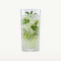 Verre transparent à long drink rempli de mojito, de glace, de menthe et de quartiers de citron vert.
