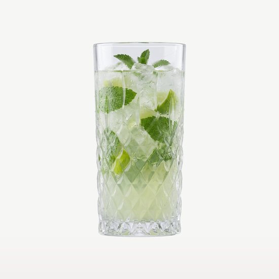 Verre transparent à long drink rempli de mojito, de glace, de menthe et de quartiers de citron vert.