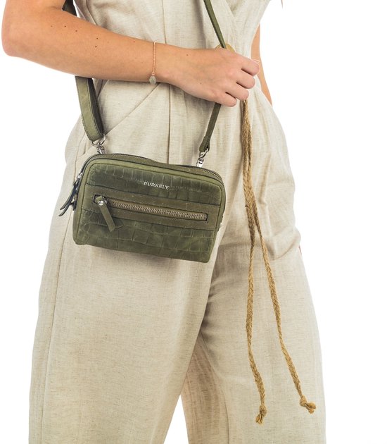Groene croco print crossbodytas, gedragen over de schouder door een vrouw.
