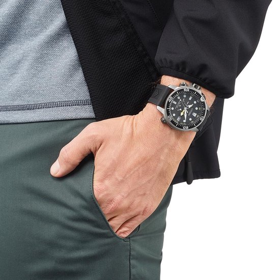 Man draagt een zilverkleurig Citizen Promaster duikhorloge met zwarte band.