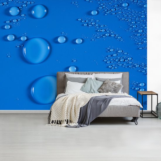 Gouttes sur un fond d' fotobehang bleu vif