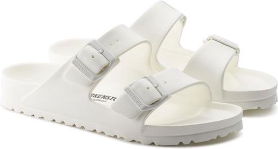 Twee witte Birkenstock Arizona EVA slippers met verstelbare gespen op beide banden.