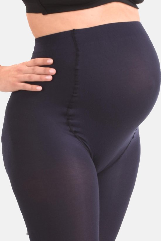 Een zwangere vrouw in een donkerblauwe panty met hoge taille, die haar buik bedekt.