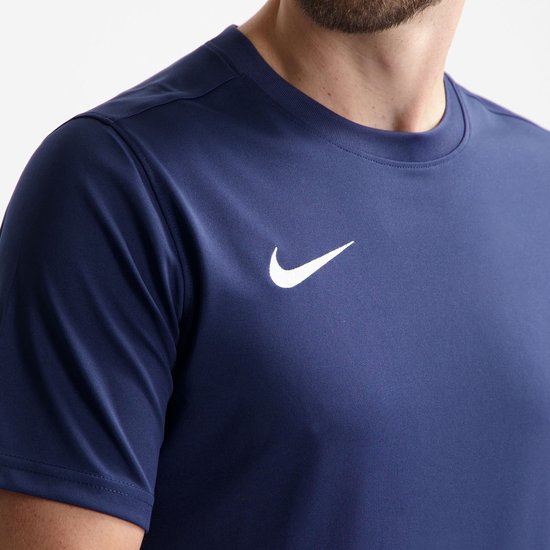 Close-up van een donkerblauw Nike sportshirt met witte Nike swoosh.