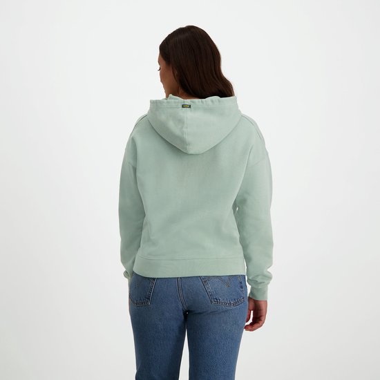 Achterkant van een mintgroene NOMAD hoodie met capuchon op een model in jeans.