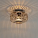 Oosterse plafondlamp aan het plafond, werpt decoratieve schaduwen door de rotan kooi.