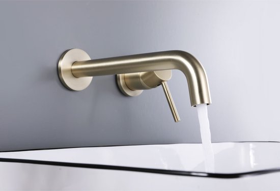 Gouden gebogen wandkraan boven een witte wastafel met zwarte rand, met water dat eruit stroomt.