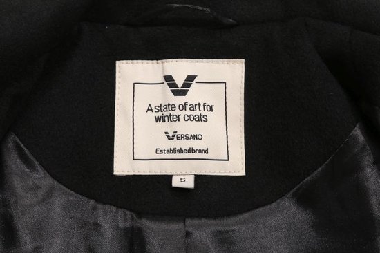 Detail van een zwart Versano knoop met logo, op een zwarte wollen jas.