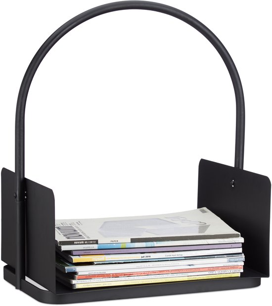 Zwarte metalen houtmand met gebogen handvat, gevuld met tijdschriften.