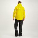 Man in volledige gele regenjas en zwarte regenbroek, van achteren.
