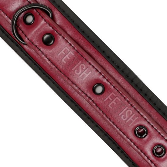 Detail van rode vegan leren polsband met metalen ogen en 'FETISH SUBMISSIVE' opdruk.