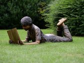 Tuinbeeld - bronzen beeld - Liggende lezende jongen - 46 cm hoog