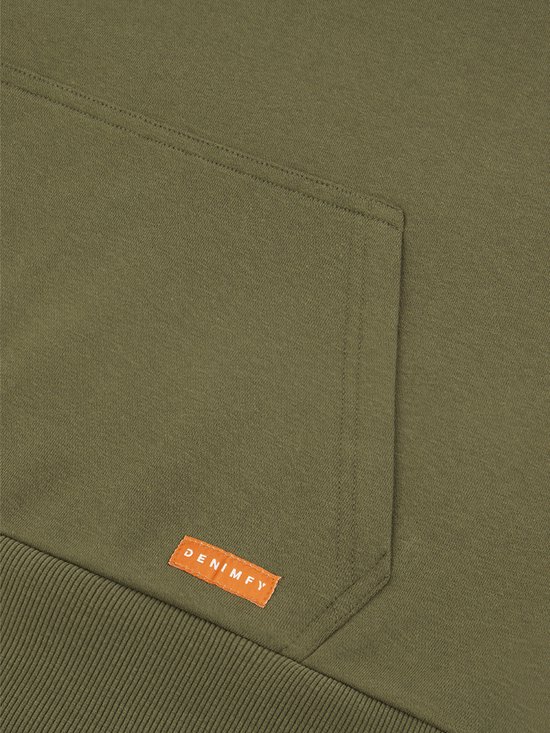 Detail van de kangoeroezak van een groene hoodie met een oranje "DENIMFY" label.