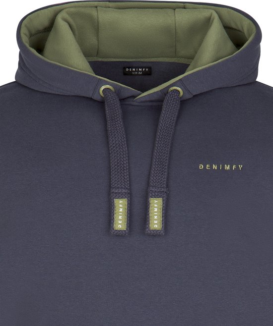 Sluiting van een donkerblauwe hoodie met capuchon, trekkoordjes en een groene voering.