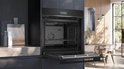 Zwarte Siemens inbouwoven, open met glazen deur, in moderne keuken.