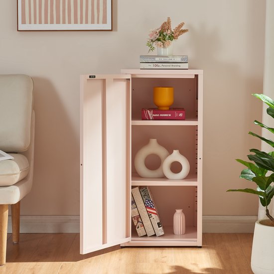 Roze metalen kast met open deur, gevuld met decoraties, in een woonkamer.