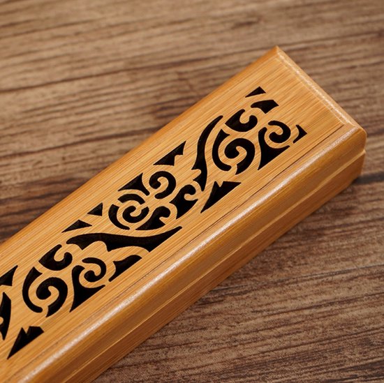 Gesloten houten wierookdoos met opengewerkte patronen en magnetische sluiting.