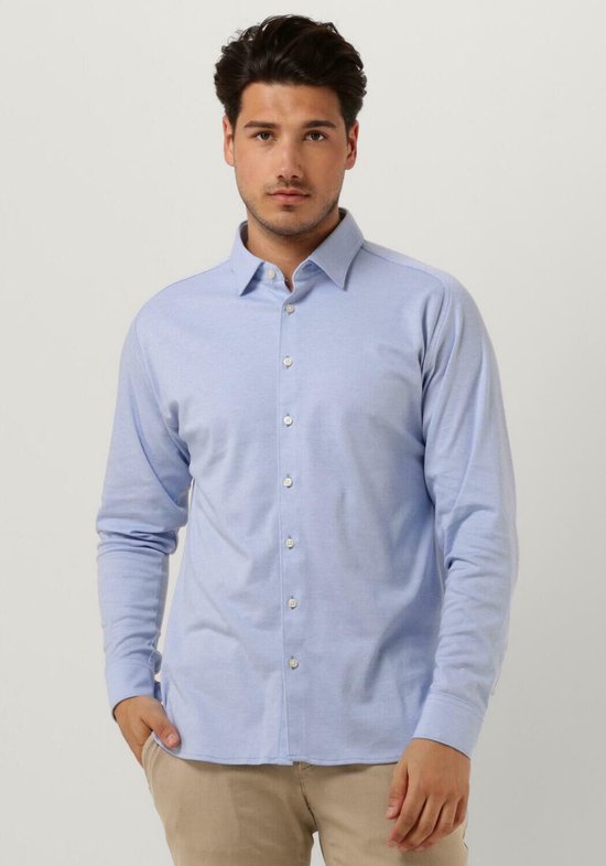 Homme portant une chemise Desoto bleu clair boutonnée avec un pantalon beige.