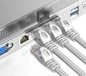 Vier grijze ethernetkabels met transparante RJ45-connectoren, aangesloten op een apparaat.