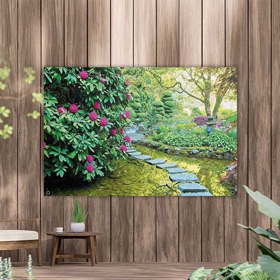 Een tuinposter met een kronkelend pad van stapstenen door een rustige vijver, omringd door weelderige groene struiken met roze bloemen.