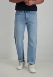 Man in lichtblauwe jeans met opgerolde broekspijpen.