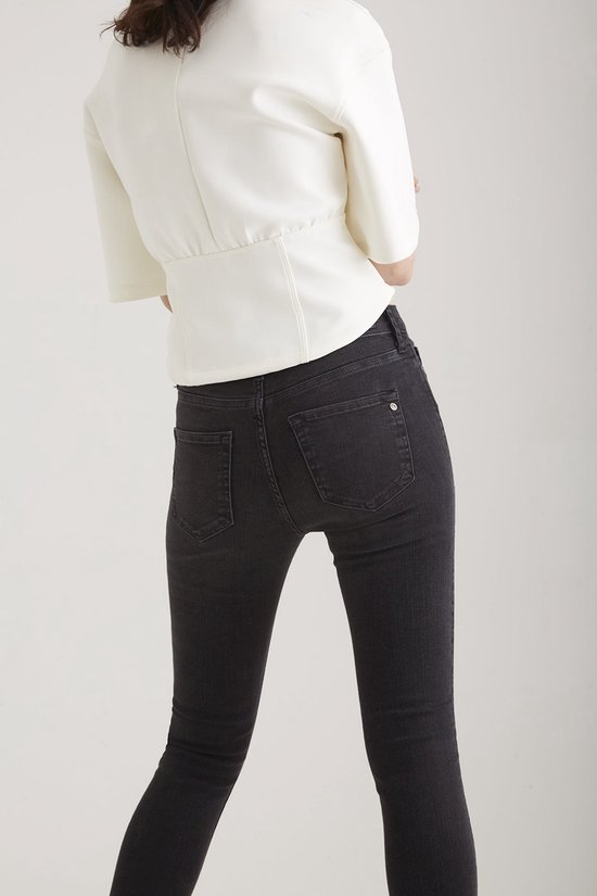 Close-up van de achterkant van de zwarte Sophia jeans bij een model.