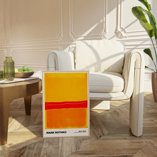 Mark Rothko poster op de vloer naast een comfortabele stoel in een woonkamer.
