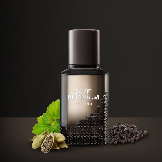David Beckham Beyond eau de toilette fles, geflankeerd door verse munt, kardemompeulen en zwarte peperkorrels.