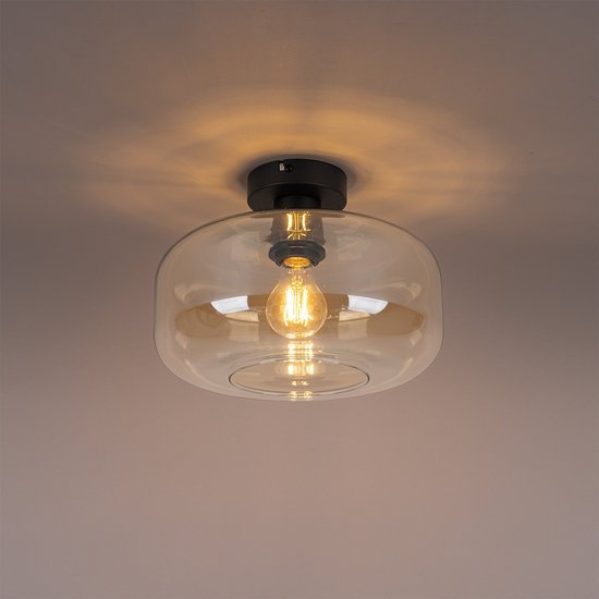 Amberkleurige glazen plafondlamp met een zwarte basis, verlicht met een peertje.