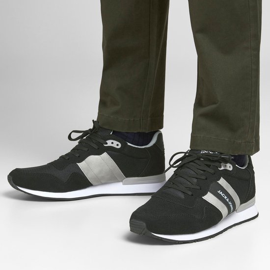 Zwarte Jack & Jones sneakers met grijze accenten en witte zool, gedragen door een model.