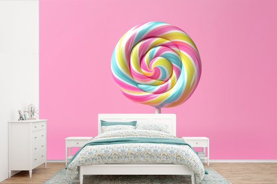 Fotobehang met een grote, roze spiraallolly boven een tweepersoonsbed met bloemenprint dekbed.