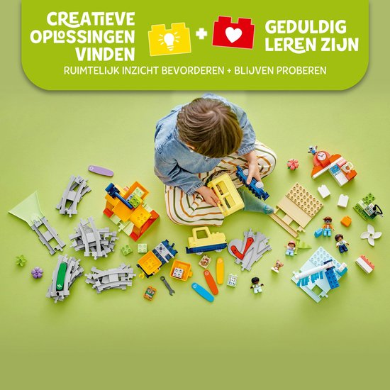 Kind bouwt LEGO Duplo treinset met rails, locomotief, wagonnen en figuren.