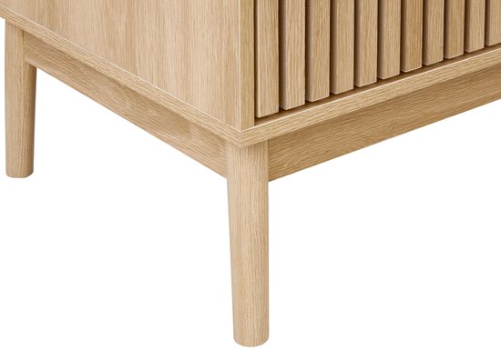 Detail van de poot en de zijkant van een licht houten tv-meubel met lamellen.
