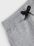 Detail van de tailleband en het trekkoord van een grijze joggingbroek.
