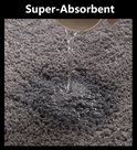 Water dat op een donkergrijs, superabsorberend badmatje valt.