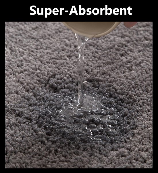 Water dat op een donkergrijs, superabsorberend badmatje valt.