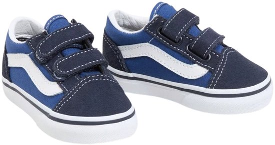 Twee blauwe Vans Old Skool V sneakers met witte streep, donkerblauwe overlays en klittenbandsluiting.
