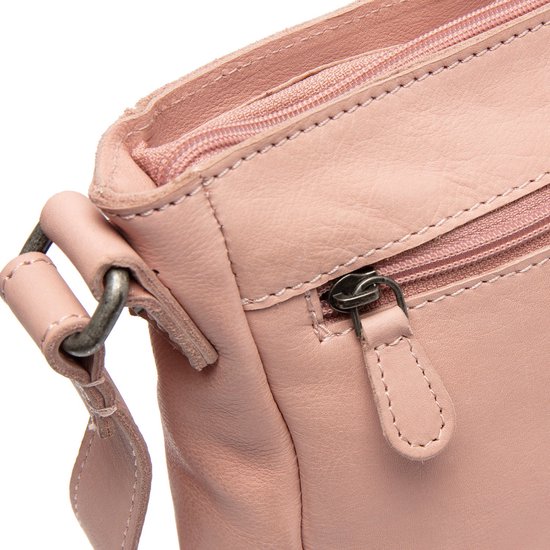 Detail van een roze leren crossbodytas met ritssluiting en metalen gesp.