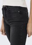 Close-up van de voorkant van een zwarte skinny jeans met een mid-waist model.