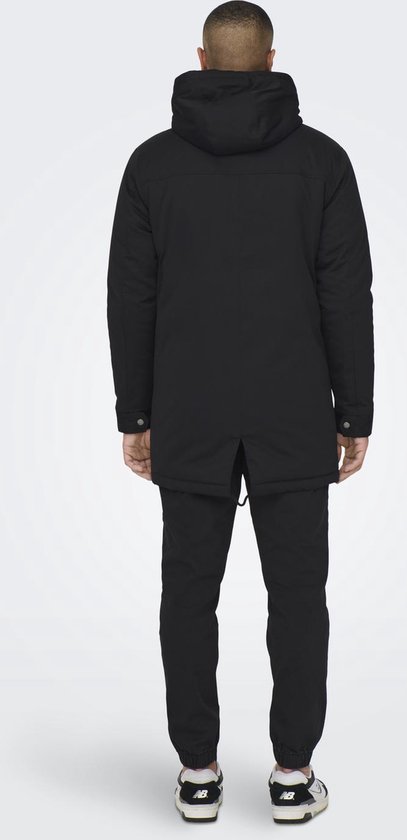 Achterkant van een zwarte parka met capuchon, gedragen door een model met een korte coupe.
