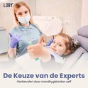 Kind met een mintgroene Loby tandenborstel met zuignapbasis op een houten vloer.