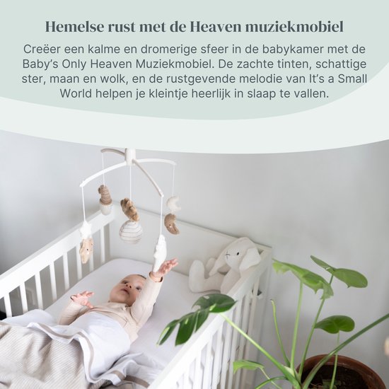 Baby in een ledikantje bij een muziek-mobiel met gebreide sterren en manen.