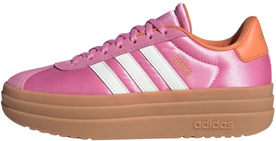 Zijaanzicht van roze Adidas sneaker met witte strepen, oranje hiel en bruine platformzool.