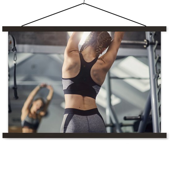jeune femme s'étire lors d'une séance de remise en forme de la commission scolaire à lattes plates noires 90x60 cm - Tirage photo sur affiche textielposter (décoration murale salon / chambre)