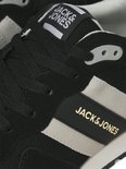 Close-up van zwarte Jack & Jones sneakers met grijze en gouden "Jack & Jones" logo.